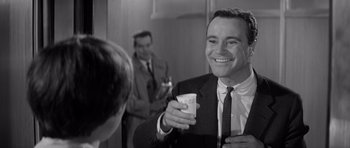 Movie still from “The Apartment” (1960), directed by Billy Wilder – A black and white photo of a man holding a cup; Close Up shot, Over the shoulder angle