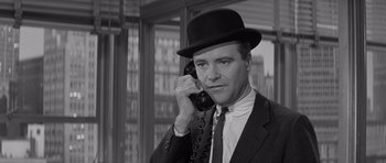 Movie still from “The Apartment” (1960), directed by Billy Wilder – A black and white photo of a man talking on a phone; Close Up shot, Low angle