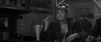 Movie still from “The Apartment” (1960), directed by Billy Wilder – A woman sitting at a table with chopsticks in her hand; Close Up shot, High angle