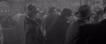 Movie still from “The Apartment” (1960), directed by Billy Wilder – A group of people standing in a room; Medium shot, High angle