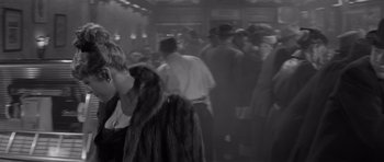 Movie still from “The Apartment” (1960), directed by Billy Wilder – A group of people standing around in a room; Medium shot, High angle