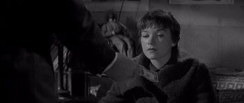 Movie still from “The Apartment” (1960), directed by Billy Wilder – A young boy holding a dollar bill in his hand; Close Up shot, Over the shoulder angle