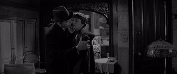 Movie still from “The Apartment” (1960), directed by Billy Wilder – A man and a woman kissing in front of a mirror; Medium shot, High angle