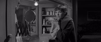 Movie still from “The Apartment” (1960), directed by Billy Wilder – A woman holding a towel in front of a bathroom mirror; Close Up shot, Low angle
