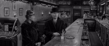 Movie still from “The Apartment” (1960), directed by Billy Wilder – A man and a woman sitting at a bar; Medium shot, High angle