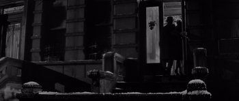 Movie still from “The Apartment” (1960), directed by Billy Wilder – A fire hydrant sitting on the side of a building; Wide shot, Low angle