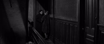 Movie still from “The Apartment” (1960), directed by Billy Wilder – A man and a woman standing next to a railing; Wide shot, High angle