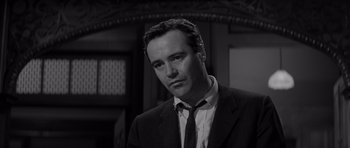 Movie still from “The Apartment” (1960), directed by Billy Wilder – Black and white photograph of a man wearing a suit and tie; Close Up shot, Low angle