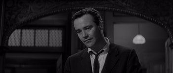 Movie still from “The Apartment” (1960), directed by Billy Wilder – Black and white photograph of a man wearing a suit and tie; Close Up shot, Low angle