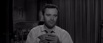 Movie still from “The Apartment” (1960), directed by Billy Wilder – A black and white photo of a man holding a bunch of money; Close Up shot, High angle