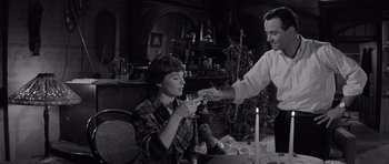 Movie still from “The Apartment” (1960), directed by Billy Wilder – A man and a woman drinking wine at a dinner table; Medium shot, Low angle