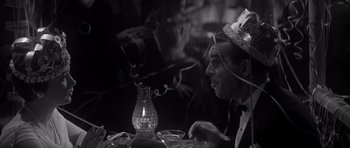 Movie still from “The Apartment” (1960), directed by Billy Wilder – An older man sitting at a table with a lit candle; Close Up shot, Overhead angle