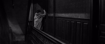 Movie still from “The Apartment” (1960), directed by Billy Wilder – A person standing in front of a wooden wall; Medium shot, High angle