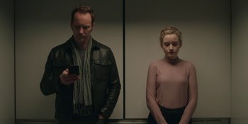 Movie still from “The Assistant” (2019), directed by Kitty Green – A man and a woman standing next to each other; Medium shot, Low angle