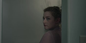 Movie still from “The Assistant” (2019), directed by Kitty Green – A young woman is looking at the camera; Close Up shot, Over the shoulder angle