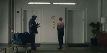 Movie still from “The Assistant” (2019), directed by Kitty Green – Two people standing in a room next to each other; Wide shot, Low angle