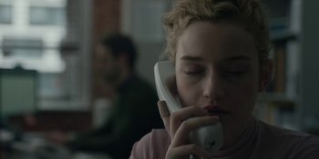 Movie still from “The Assistant” (2019), directed by Kitty Green – A woman is talking on a phone while sitting in a room; Close Up shot, Low angle