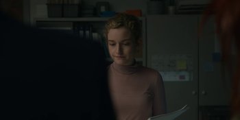 Movie still from “The Assistant” (2019), directed by Kitty Green – A woman in a pink shirt is looking at a paper; Close Up shot, Over the shoulder angle