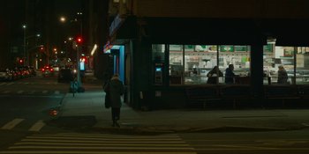 Movie still from “The Assistant” (2019), directed by Kitty Green – A person walking on the sidewalk at night; Extreme Wide shot, High angle