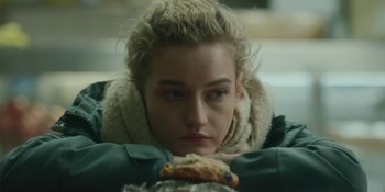 Movie still from “The Assistant” (2019), directed by Kitty Green – A woman is looking down at a piece of food; Close Up shot, Over the shoulder angle