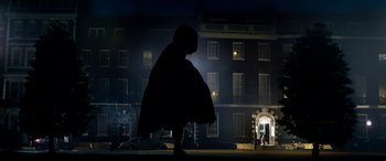 Movie still from “The BFG” (2016), directed by Steven Spielberg – A person standing in front of a building at night; Extreme Wide shot, Low angle