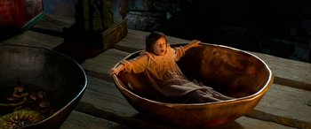 Movie still from “The BFG” (2016), directed by Steven Spielberg – A young girl is sitting in a wooden bowl; Wide shot, High angle