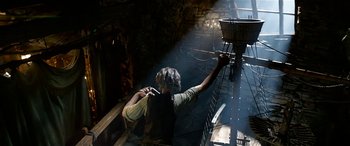 Movie still from “The BFG” (2016), directed by Steven Spielberg – A man is working in a factory with a bucket; Wide shot, Low angle
