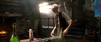 Movie still from “The BFG” (2016), directed by Steven Spielberg – An old man standing next to a young girl; Wide shot, Low angle