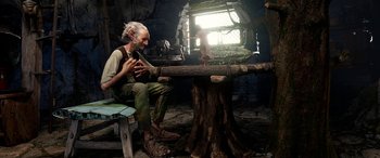 Movie still from “The BFG” (2016), directed by Steven Spielberg – An old man sitting at a table in a room; Wide shot, Over the shoulder angle