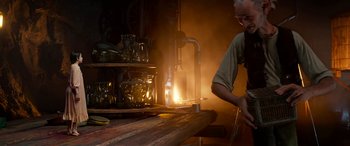 Movie still from “The BFG” (2016), directed by Steven Spielberg – A man working in an industrial setting with smoke coming out of the background; Medium shot, Low angle