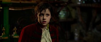 Movie still from “The BFG” (2016), directed by Steven Spielberg – A young girl wearing a red jacket looking at the camera; Close Up shot, Over the shoulder angle
