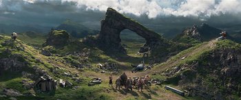 Movie still from “The BFG” (2016), directed by Steven Spielberg – A group of people standing on top of a lush green field; Extreme Wide shot, High angle