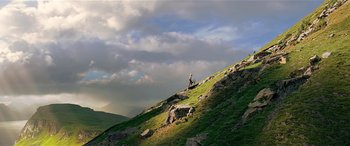 Movie still from “The BFG” (2016), directed by Steven Spielberg – A person standing on a hill with a sky in the background; Extreme Wide shot, Low angle