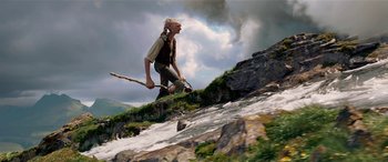 Movie still from “The BFG” (2016), directed by Steven Spielberg – A man walking up a hill near a river; Wide shot, Low angle
