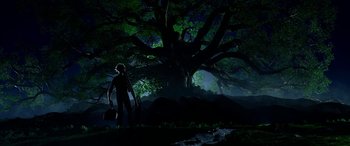 Movie still from “The BFG” (2016), directed by Steven Spielberg – A man standing in front of a tree at night; Extreme Wide shot, Low angle