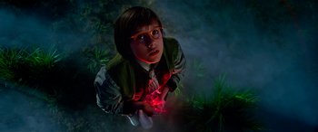 Movie still from “The BFG” (2016), directed by Steven Spielberg – A young boy wearing glasses and holding a red object in his hand; Medium shot, Overhead angle