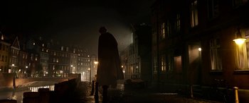 Movie still from “The BFG” (2016), directed by Steven Spielberg – A person walking down a street at night; Wide shot, Low angle
