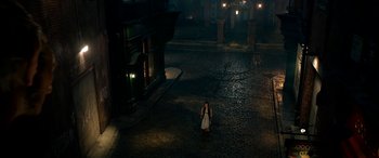 Movie still from “The BFG” (2016), directed by Steven Spielberg – A woman standing in the middle of a street at night; Extreme Wide shot, High angle