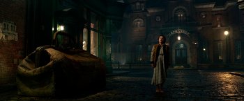 Movie still from “The BFG” (2016), directed by Steven Spielberg – A woman standing in the middle of a dark room; Wide shot, High angle