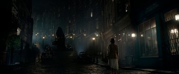 Movie still from “The BFG” (2016), directed by Steven Spielberg – A woman standing on the side of a street at night; Extreme Wide shot, Low angle