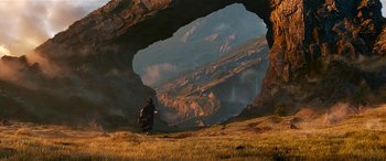 Movie still from “The BFG” (2016), directed by Steven Spielberg – A man is walking through a cave in the mountains; Extreme Wide shot, Low angle