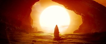 Movie still from “The BFG” (2016), directed by Steven Spielberg – A person standing in front of an open cave with the sun in the background; Wide shot, Low angle