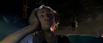 Movie still from “The BFG” (2016), directed by Steven Spielberg – An old man with a beard is holding his hand to his head; Close Up shot, Low angle
