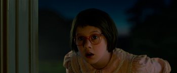 Movie still from “The BFG” (2016), directed by Steven Spielberg – A young girl wearing glasses looking at the camera; Close Up shot, Over the shoulder angle