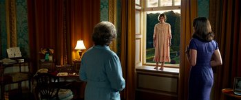 Movie still from “The BFG” (2016), directed by Steven Spielberg – An older woman standing in front of an open window; Wide shot, High angle