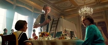 Movie still from “The BFG” (2016), directed by Steven Spielberg – An older man standing in front of a table; Medium shot, Over the shoulder angle