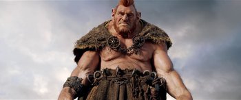 Movie still from “The BFG” (2016), directed by Steven Spielberg – An image of an old man with a beard and a chain around his neck; Medium shot, Low angle