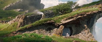 Movie still from “The BFG” (2016), directed by Steven Spielberg – A mountain with rocks and trees in the background; Extreme Wide shot, Low angle