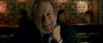 Movie still from “The Best Exotic Marigold Hotel” (2011), directed by John Madden – An old man with a beard and a suit is smiling; Close Up shot, Low angle