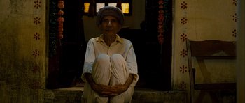 Movie still from “The Best Exotic Marigold Hotel” (2011), directed by John Madden – An old man sitting on the steps of a house; Medium shot, High angle